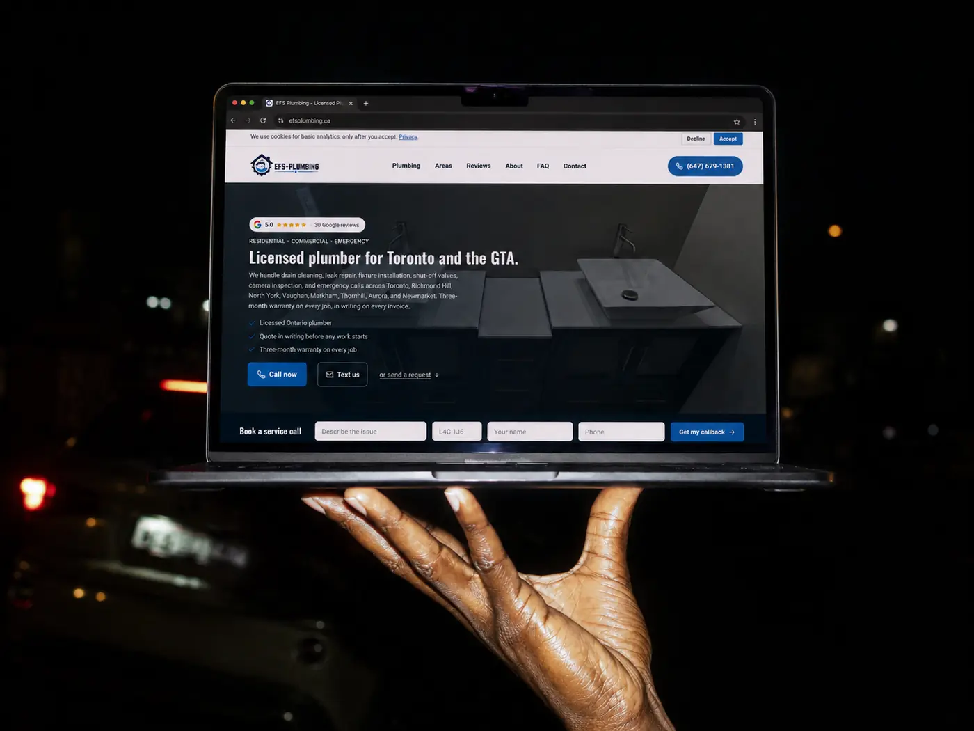 The EFS Plumbing website Fervor built, shown on a MacBook held at night