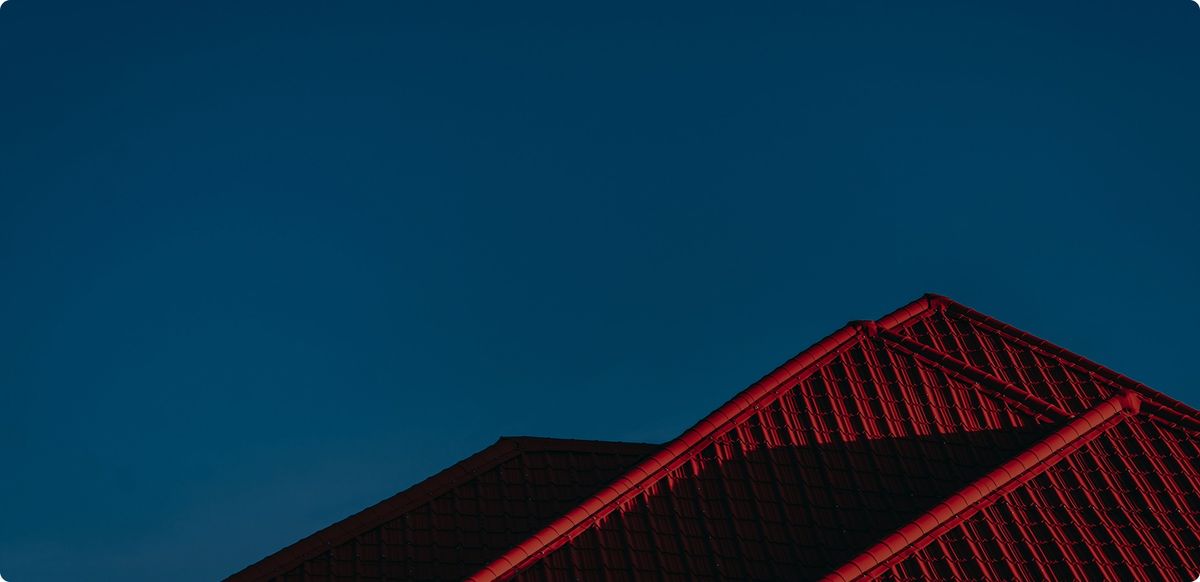 Red tile rooftop against a dark blue sky